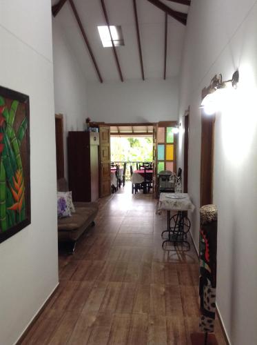 a living room with a hallway with a table and chairs at Finca El Sueño De Mi Abuelo in Pereira