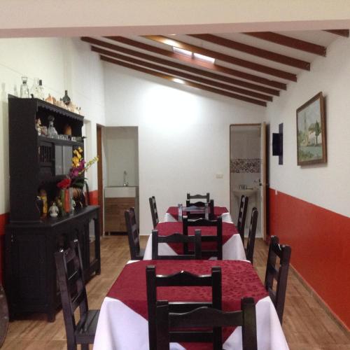 a dining room with tables and chairs with red tablecloths at Finca El Sueño De Mi Abuelo in Pereira