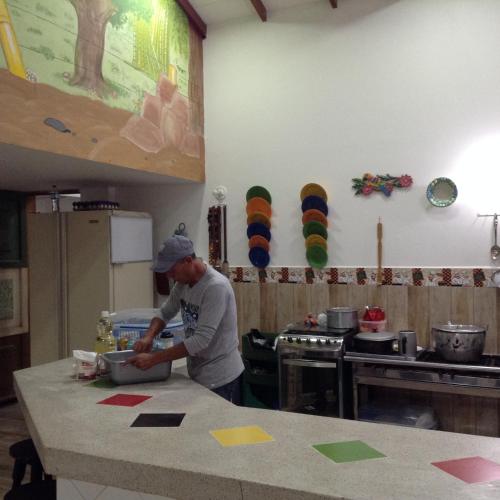 a man standing in a kitchen preparing food at Finca El Sueño De Mi Abuelo in Pereira