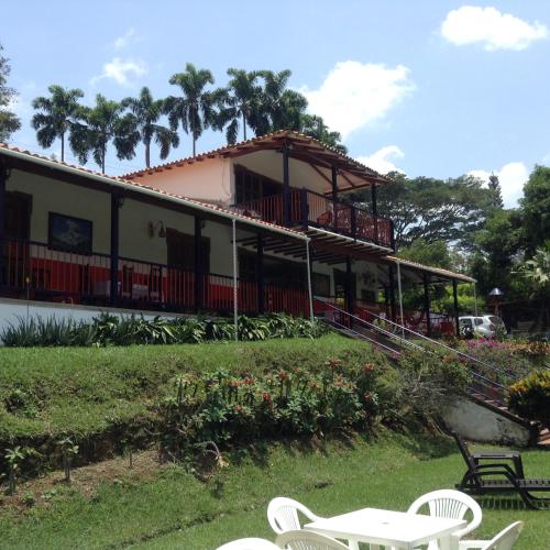 a building with a table and chairs in front of it at Finca El Sueño De Mi Abuelo in Pereira