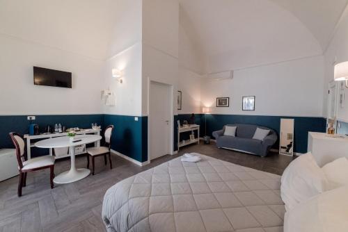 a bedroom with a bed and a table and a couch at Novecento Dimore di Poesia in Trani