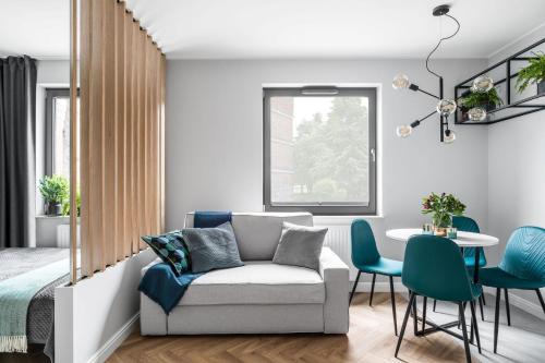 een woonkamer met een bank, een tafel en stoelen bij Ideal Apartments Green & Blue in Gdańsk
