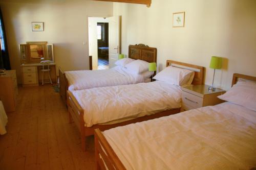 a hotel room with three beds and a mirror at Loire Escapes - Maison D'Hibou in Berrie