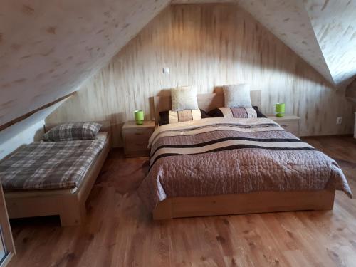 sypialnia z łóżkiem i ławką na poddaszu w obiekcie Apartmán Bianka w mieście Rabča