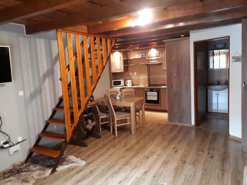 a kitchen and dining room with a wooden staircase in a room at Apartmán Bianka in Rabča