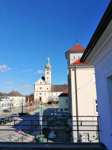 Pension Geschriebenstein في Lochenhaus: اطلالة من بلكونة على مبنى مع برج الساعة