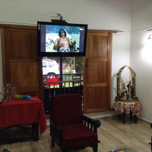 a living room with a tv and a chair at Finca El Sueño De Mi Abuelo in Pereira