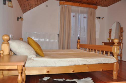a bedroom with a wooden bed with white sheets at Turistična kmetija Lesjak in Šmihel nad Mozirjem