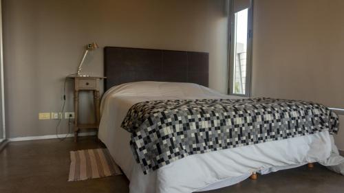 1 dormitorio con 1 cama con manta blanca y negra en Humboldt 1945 - Ayres Apartments en Buenos Aires