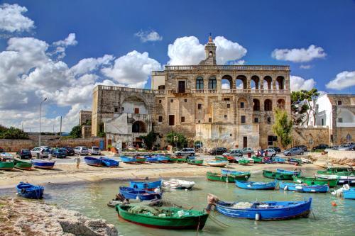 un gruppo di barche in acqua di fronte a un edificio di Polignano Casa Vacanze a Polignano a Mare