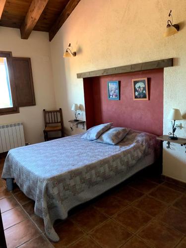 a bedroom with a large bed in a room at Masia de la Serra de la Cogulla in Peñarroya de Tastavins