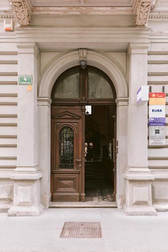an entrance to a building with a wooden door at Fluxus Hostel in Ljubljana