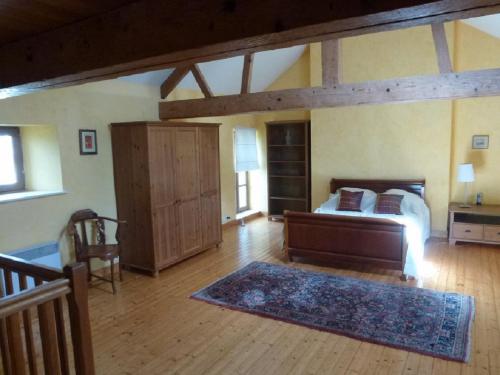une chambre avec un lit et un parquet dans l'établissement La Petite Maison, à Bricqueville