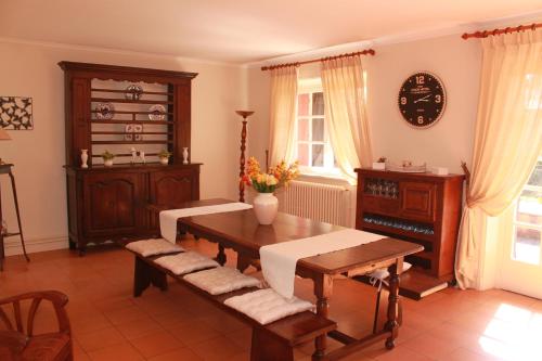 uma sala de estar com uma mesa e banco de madeira e um relógio em Appartements de Chantaco em Saint-Jean-de-Luz
