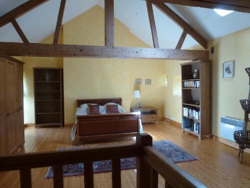 une grande pièce avec un lit et une étagère dans l'établissement La Petite Maison, à Bricqueville
