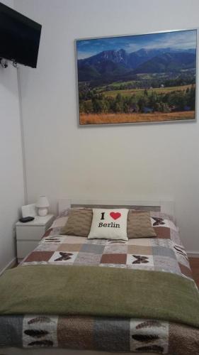 a bedroom with a bed with a picture on the wall at Ferienwohnung in Berlin