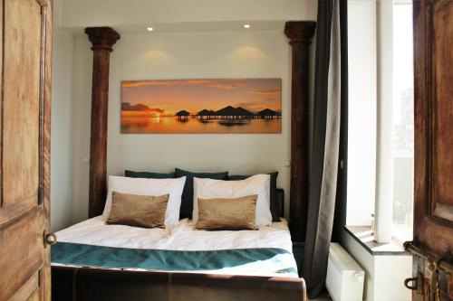 a bedroom with a bed with a painting on the wall at Atica Penthouse in Tallinn
