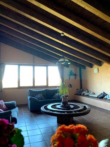 a living room with a couch and a table at Masia de la Serra de la Cogulla in Peñarroya de Tastavins