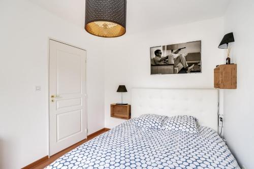 a bedroom with a bed and a picture on the wall at Votre Escale - Le petit Montmartre in Niort