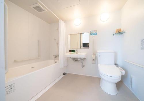 Baño blanco con aseo y lavamanos en Iwaki - Hotel / Vacation STAY 22982, en Iwaki