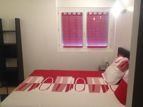 - une chambre avec un lit rouge et blanc et une fenêtre dans l'établissement Appartement proche Centre Ville avec PARKING PRIVE, à Avignon