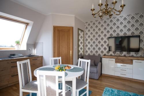 a kitchen and living room with a table and chairs at Apartamenty Ciche Wzgórze Zakopane in Zakopane