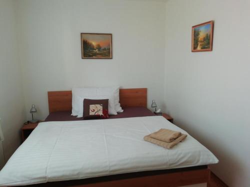 a bedroom with a large bed with two pictures on the wall at Motorest U Kola in Prostějov