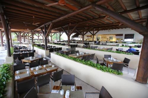 a restaurant with tables and chairs in a building at Pacifica Resort Ixtapa in Ixtapa