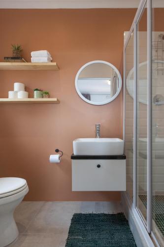 a bathroom with a sink and a mirror at Seascape Cottage in Simonʼs Town