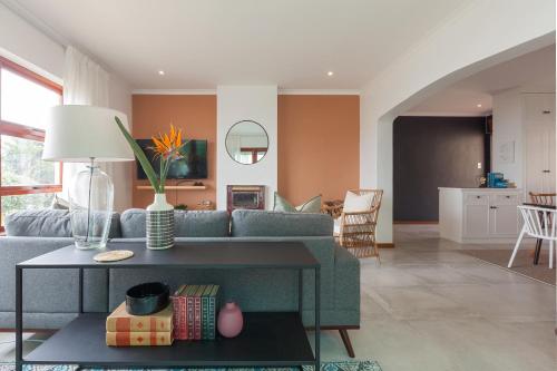 een woonkamer met een bank en een tafel bij Seascape Cottage in Kaapstad
