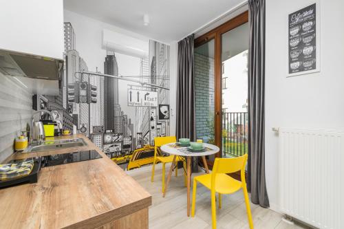 a kitchen with yellow chairs and a table in a kitchen at Prime Apartments in Warsaw