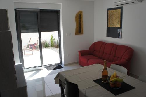 a living room with a red couch and a table at Apartment White in Vantačići