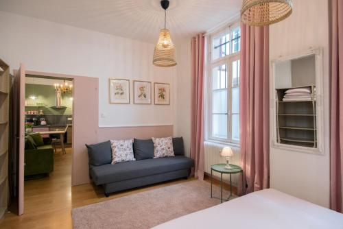 un soggiorno con divano blu e finestra di " Mademoiselle " 17 Boulevard du Champ de Mars a Colmar