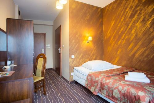 a hotel room with a bed and a wooden wall at Hotel Karino Spa in Polańczyk