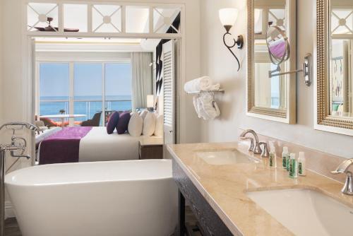 een badkamer met een bad en een slaapkamer met een bed bij Jewel Grande Montego Bay Resort and Spa in Montego Bay