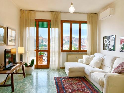 sala de estar con sofá blanco y TV en Attico San Francesco en Siena