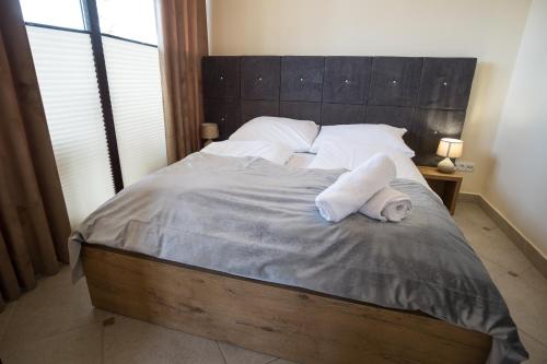 a bedroom with a bed with two towels on it at Apartamenty Ciche Wzgórze Zakopane in Zakopane