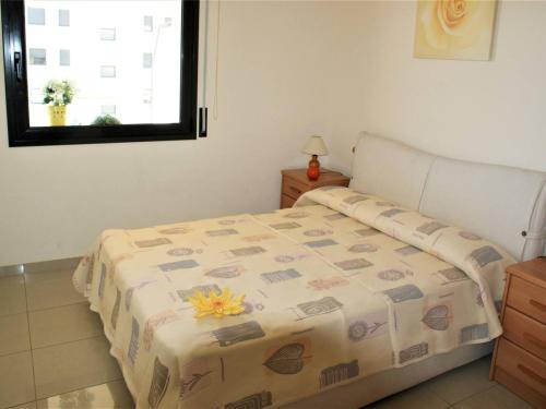 Un dormitorio con una cama con una flor. en APARTAMENTO EN ROSES A 2 MINUTOS DE LA PLAYA CON VISTA AL MAR, en Girona