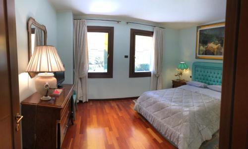 a bedroom with a bed and a table with a lamp at Villa Fior di Robinia in Giavera del Montello