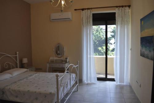- une chambre avec un lit et une porte coulissante en verre dans l'établissement Park House -beside the Medieval Town of Rhodes, à Rhodes