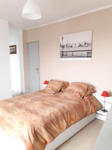 ein Schlafzimmer mit einem Bett mit einer Bettdecke darauf in der Unterkunft Tiguil in Le Guilvinec