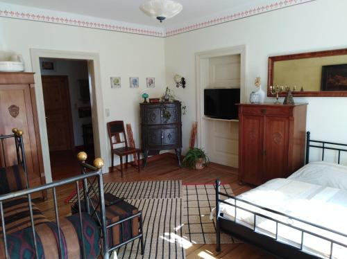 a bedroom with a bed and a flat screen tv at Anno-Nostalgia in Rheinsberg