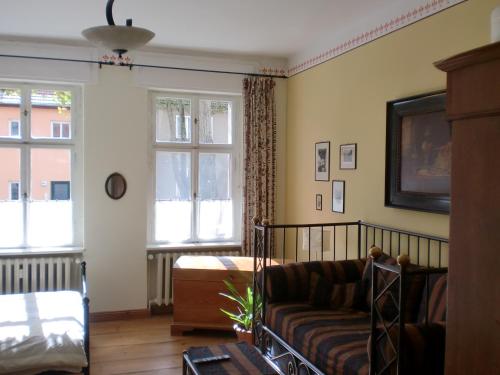 a living room with a couch and two windows at Anno-Nostalgia in Rheinsberg