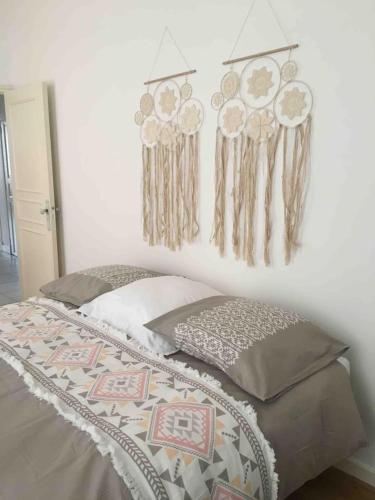 - une chambre dotée d'un lit avec des lobbons de rêve accrochés au mur dans l'établissement Place Carnot, à Carcassonne