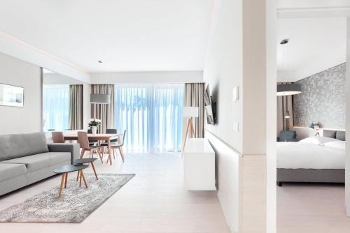 a bedroom and a living room with a couch and a table at Mielno Dune B Apartamenty in Mielno