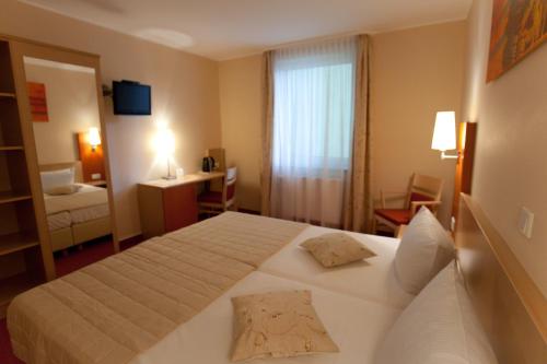 ein Hotelzimmer mit einem Bett und einem Fenster in der Unterkunft Hotel Petersburg Superior in Düsseldorf
