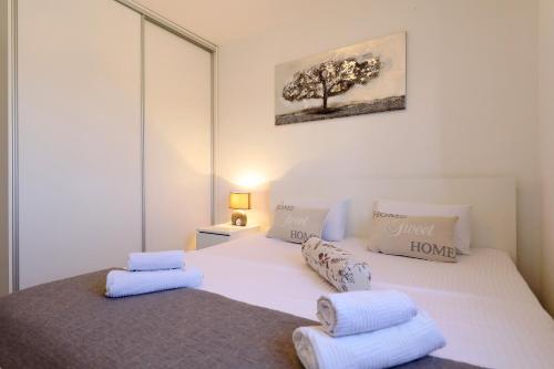 una camera da letto con un letto bianco con due cuscini sopra di Holiday house MIA a Murvica