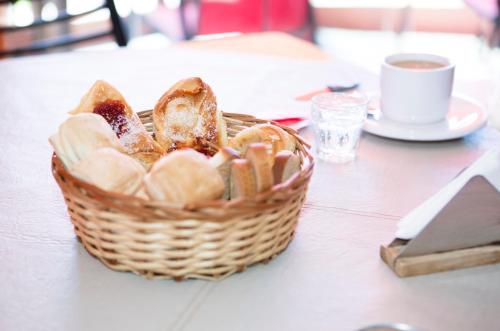 una cesta de pan en una mesa con una taza de café en Hotel Los Aromos, en Mina Clavero