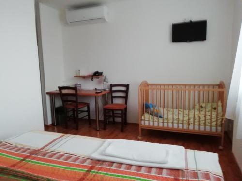 a bedroom with a crib and a table and chairs at Motorest U Kola in Prostějov