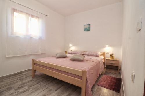 1 dormitorio con cama con sábanas rosas y ventana en STUDIO APARTMAN EDY 3 en Pula